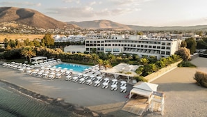 Un hotel con piscina, tumbonas y vistas del paisaje circundante.