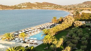 Un resort con piscina, tumbonas y vistas al mar.