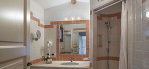 A bathroom with a sink, mirror, and shower. - Stelle Marine (Arzachena)