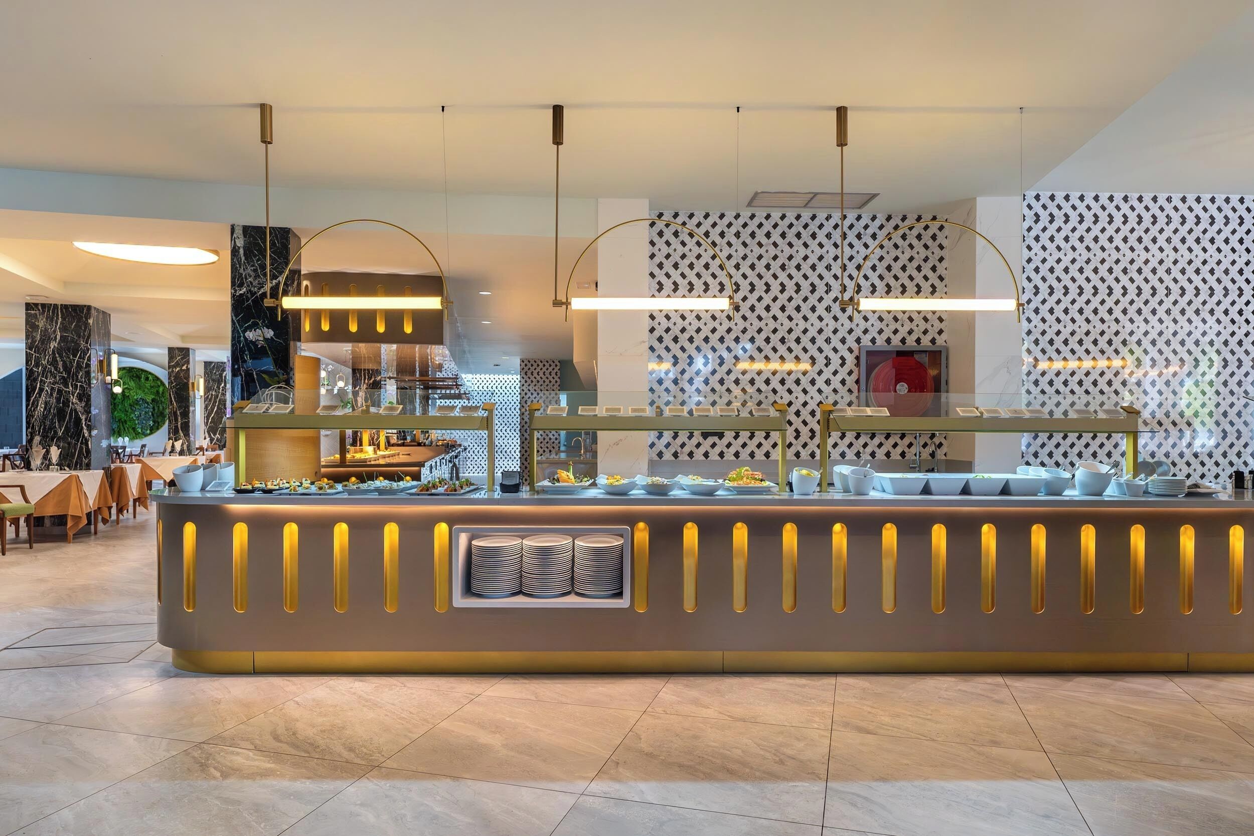 A buffet area with a marble counter, overhead lighting, and a patterned wall in the background.