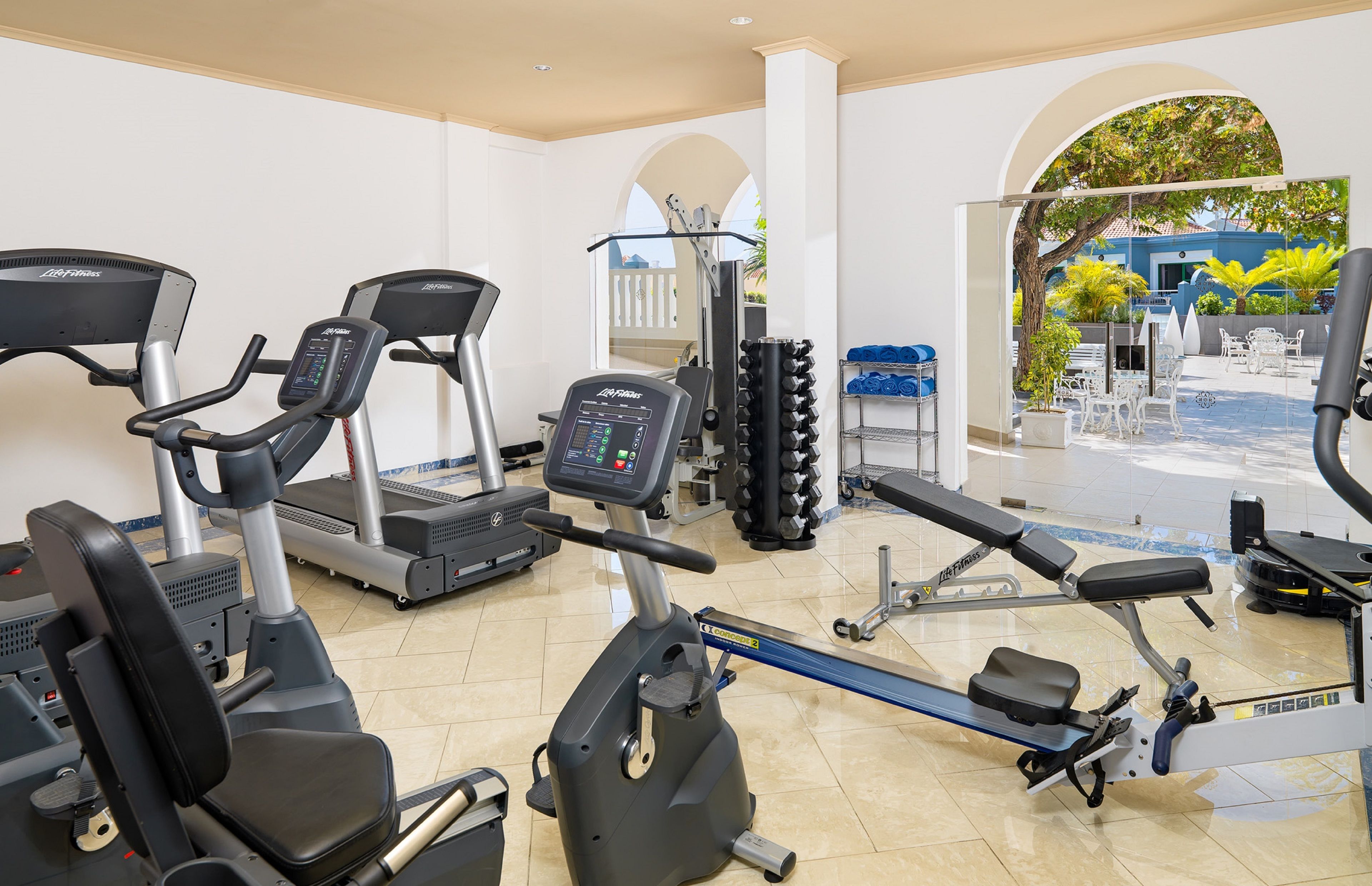 A gym with treadmills, elliptical machines, and weight equipment.
