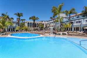 A pool area with lounge chairs and palm trees. - Hotel Colón Guanahaní Adults Only (Adeje)
