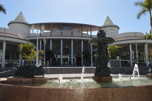 Un hôtel doté d’une fontaine centrale et de colonnes à l’entrée.