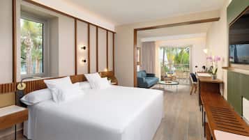 Una habitación de hotel con una cama grande, un escritorio, una silla, un sofá y un televisor.