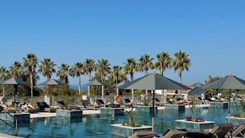 Una piscina cubierta, una piscina al aire libre, sombrillas, tumbonas