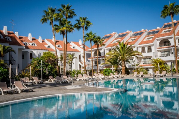 A resort pool area with lounge chairs and palm trees. - Paradise Park Fun Lifestyle Hotel (Arona)