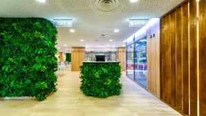 A hallway with a green wall and a wooden panel wall, leading to an entrance. - Paradise Park Fun Lifestyle Hotel (Arona)