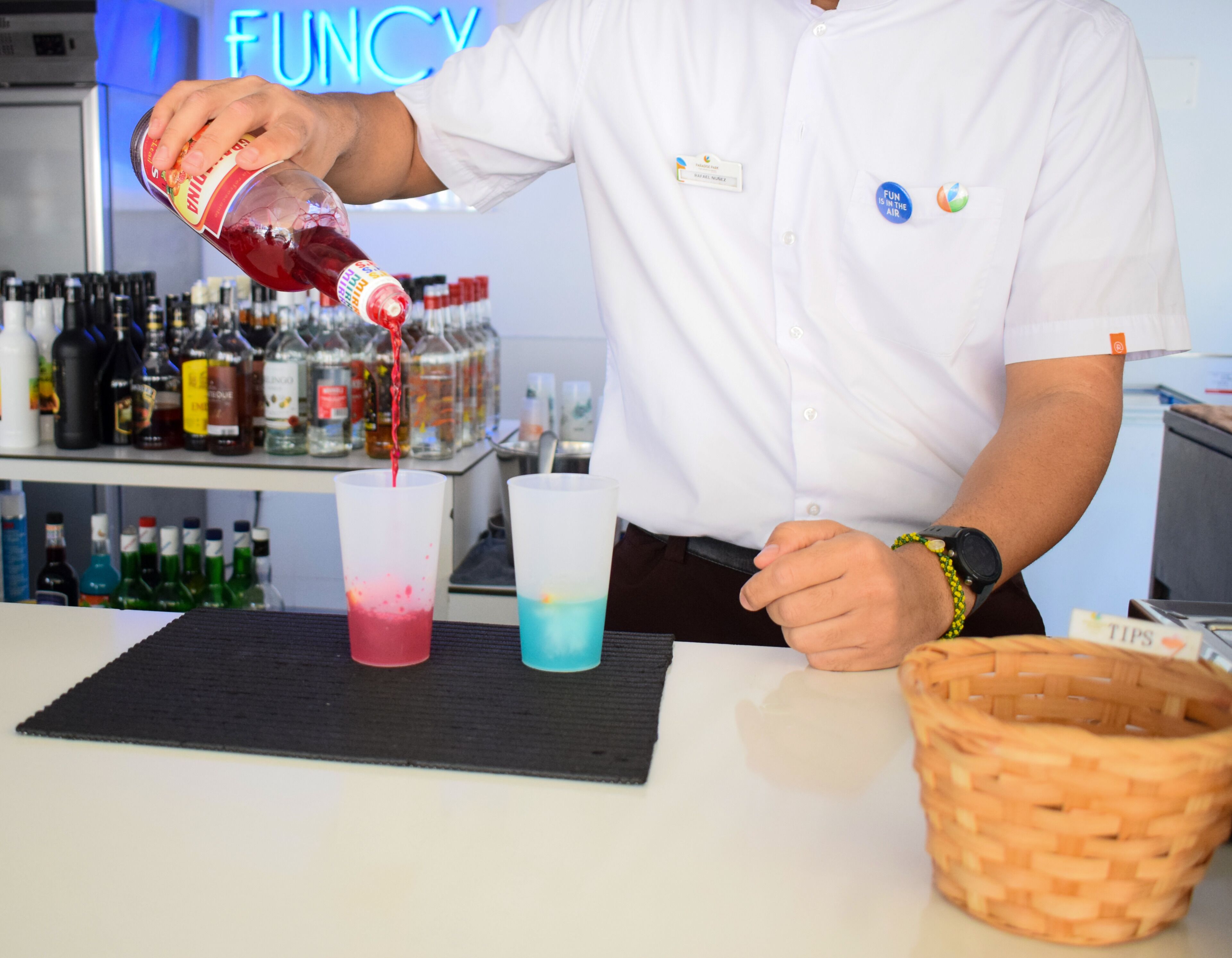 A bartender pouring a drink into a glass.