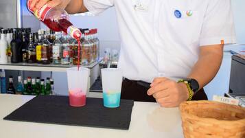 A bartender pouring a drink into a glass.