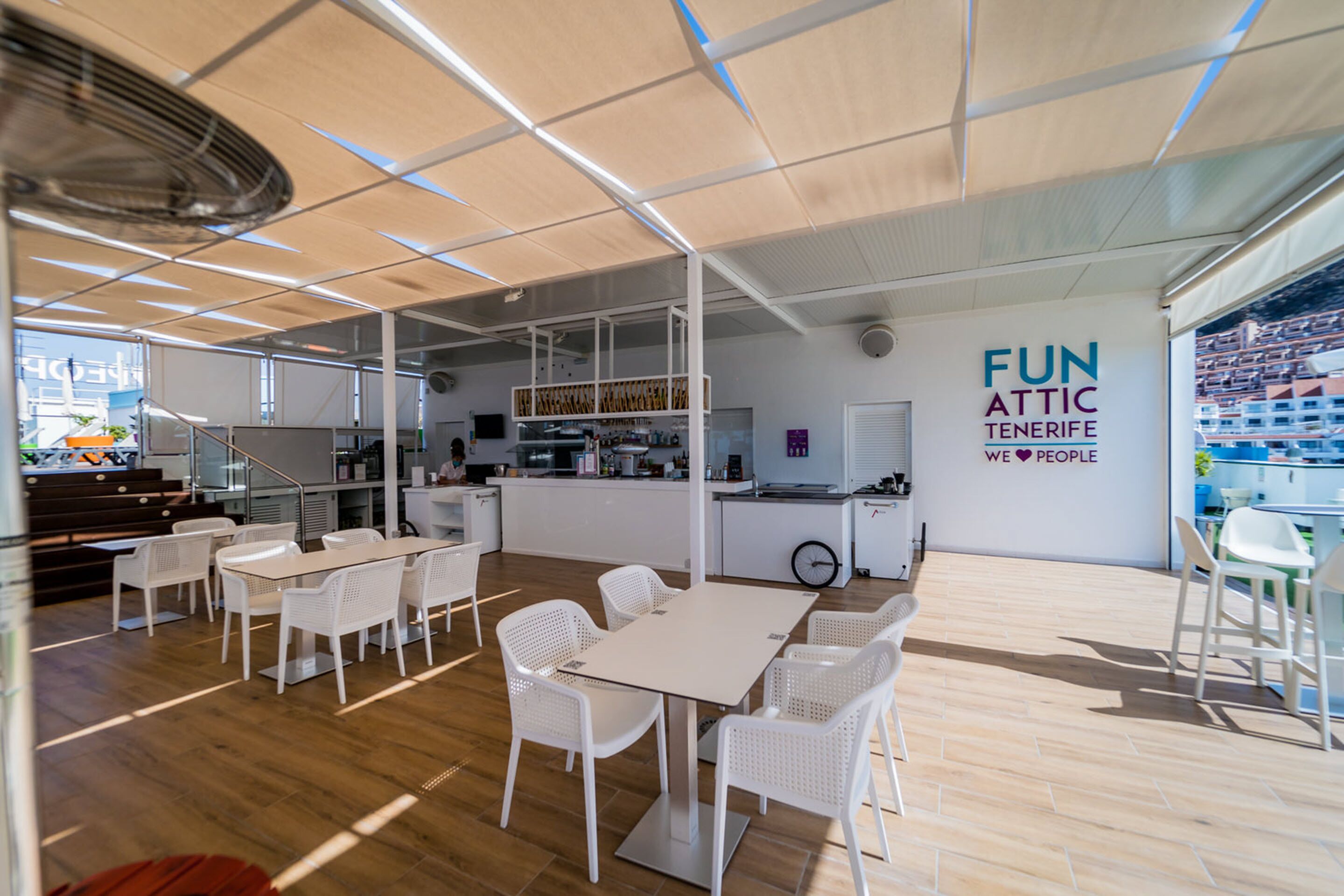 Een moderne, open ruimte met een eethoek, keuken en bar.