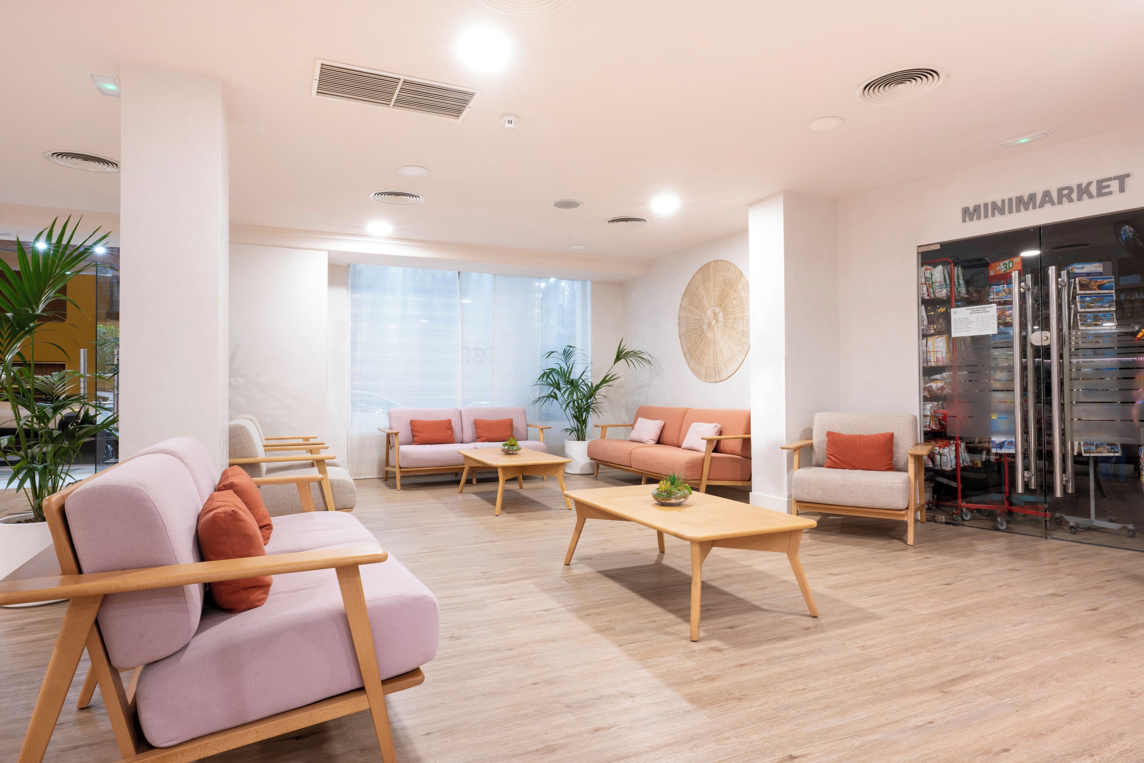 A modern interior with sofas, coffee tables, and a Minimarket.