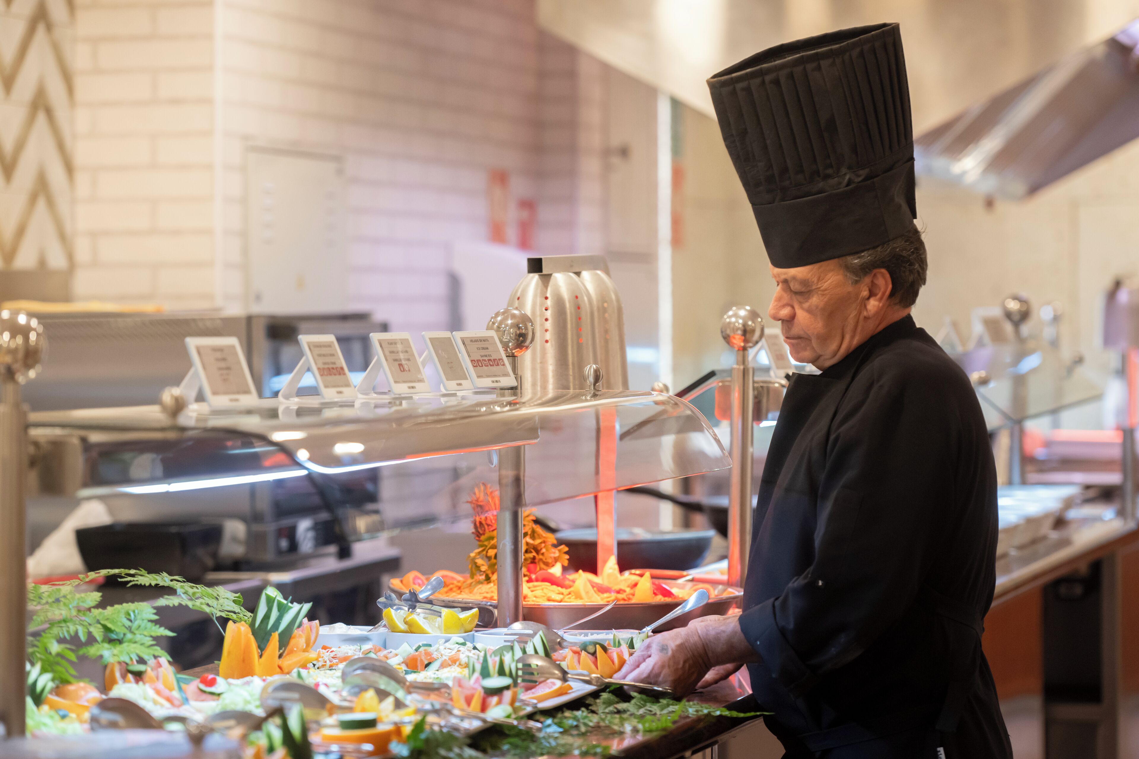 A buffet area with various food items and a person serving.