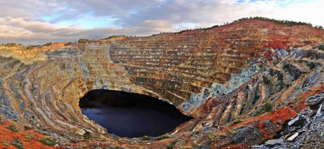 A large open-pit mine with steep, terraced walls and a central void.