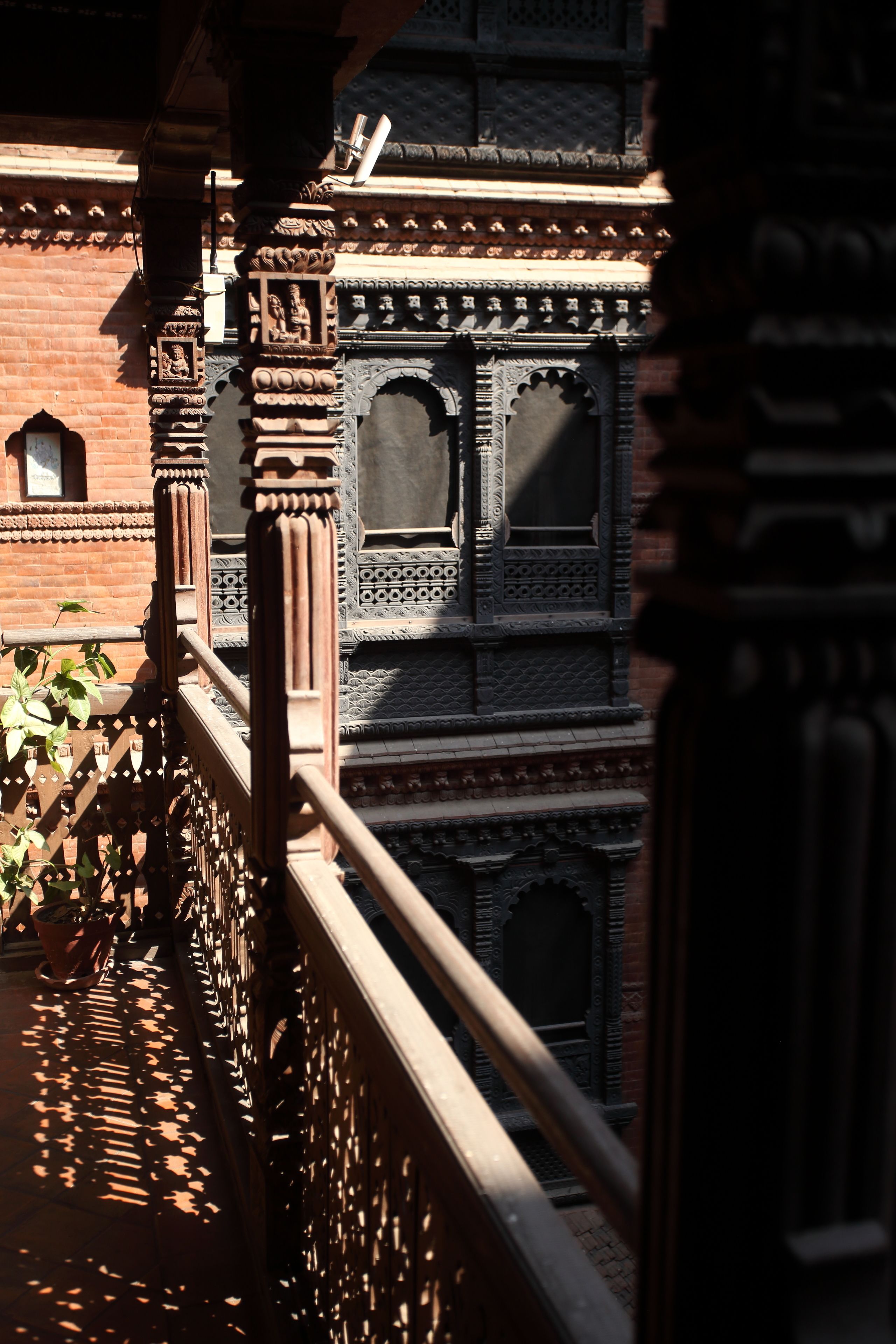 A balcony with ornate railings and a view of a building with intricate architectural details.