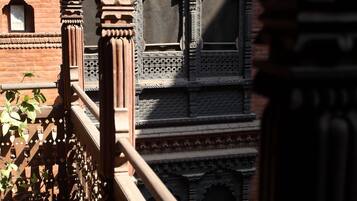 A balcony with ornate railings and a view of a building with intricate architectural details.