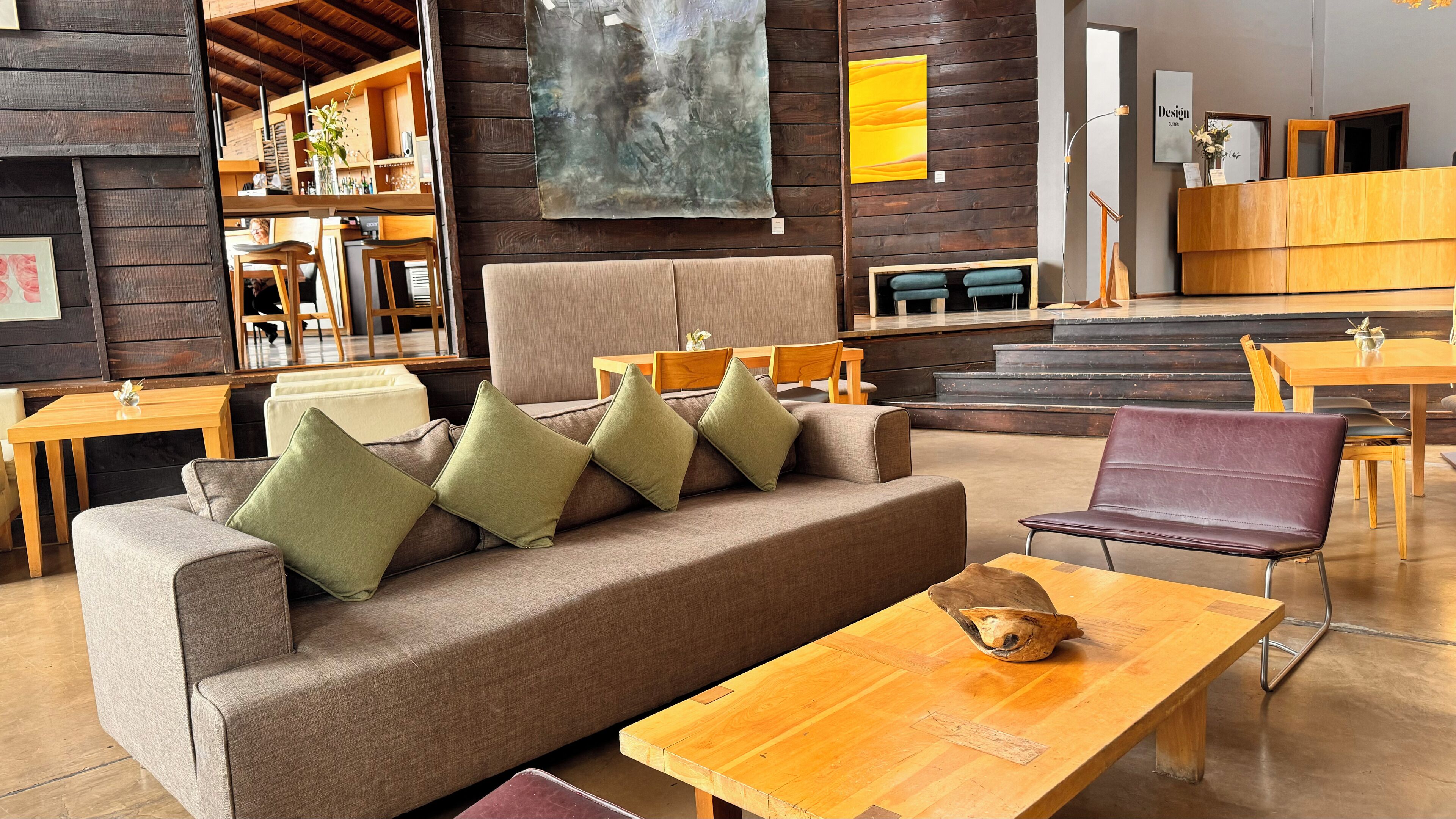 A cozy, modern lounge area with a sofa, chairs, and a wooden coffee table.
