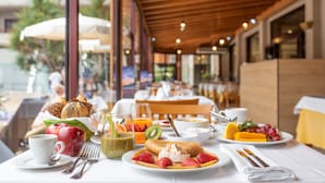 Una mesa con una variedad de alimentos para el desayuno, como frutas, pasteles y bebidas.