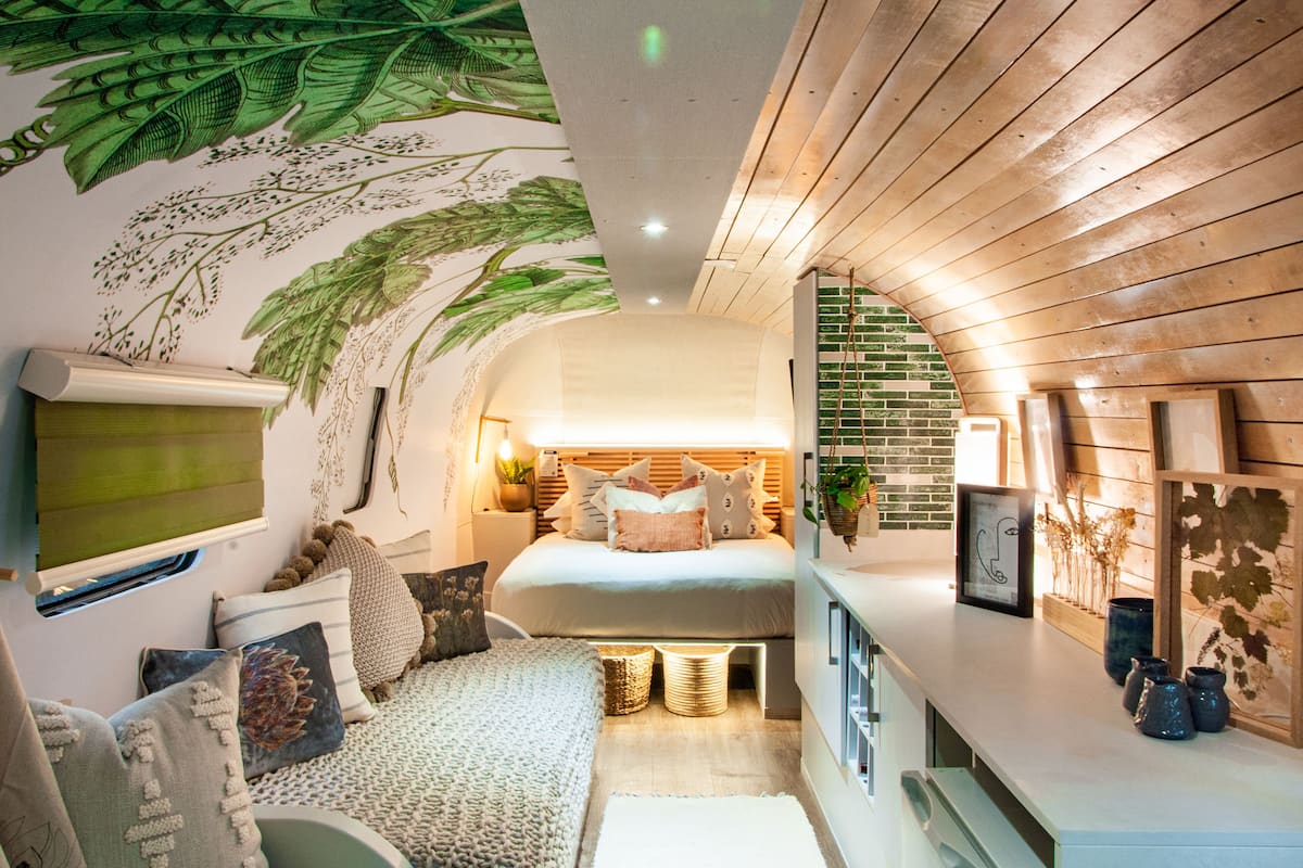 Ein gemütliches Schlafzimmer mit einem Bett, Kissen und einem Wandbild.