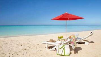 Playa privada, arena blanca, sombrillas y toallas de playa