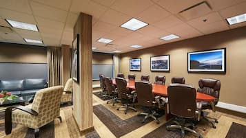 A conference room with a long table, leather chairs, and a sofa.