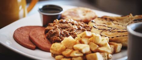 Un plato con salchicha en rodajas, frijoles, queso a la plancha y papas.