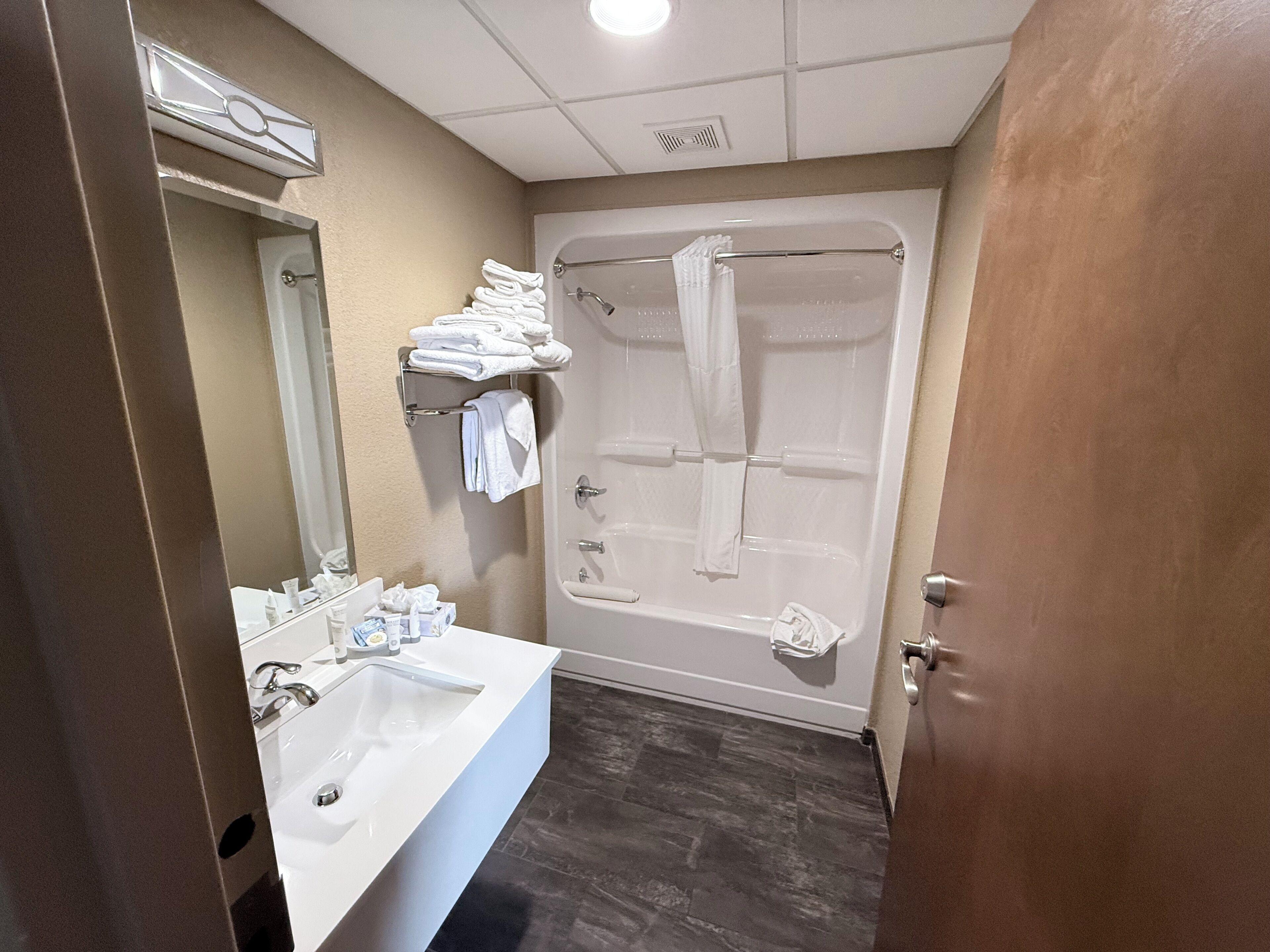 Une salle de bain équipée d’un lavabo, d’un miroir, d’un porte-serviettes et d’une baignoire.