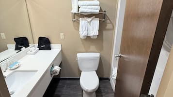 Un baño con lavamanos, inodoro y perchero para toallas.
