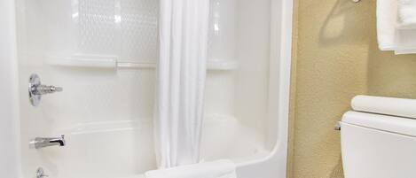 A bathroom with a bathtub, toilet, and towel rack.