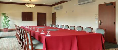 A conference room with a long table, chairs, and a chandelier.