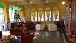 A lobby with a seating area, a large plant, and a patterned floor. - Hotel Belvedere (Portovenere)