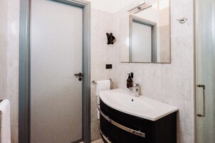 A bathroom with a white sink, a mirror, and a towel rack.