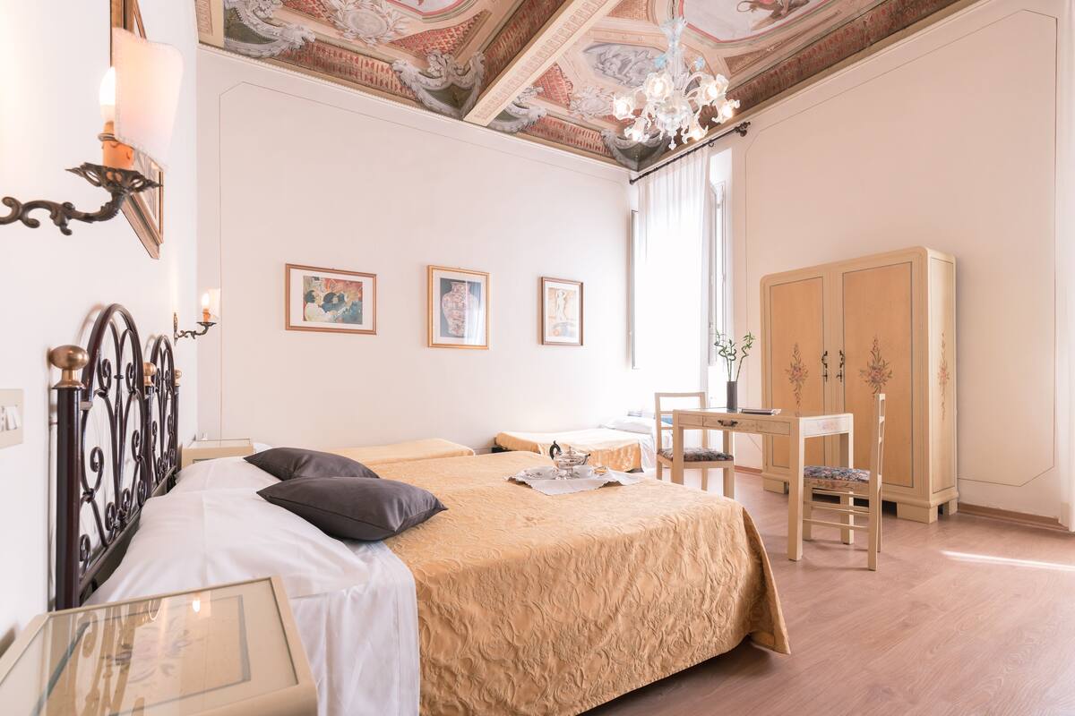A bedroom with a bed, a desk, a chair, and a wardrobe.