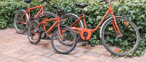 Tres bicicletas aparcadas en un camino de ladrillo.