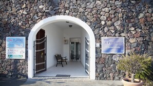 A stone building with an arched entrance, a bench, and signs for 'Hotel A Pinnata' and 'Filipino Restaurant'. - Hotel A' Pinnata (Lipari)