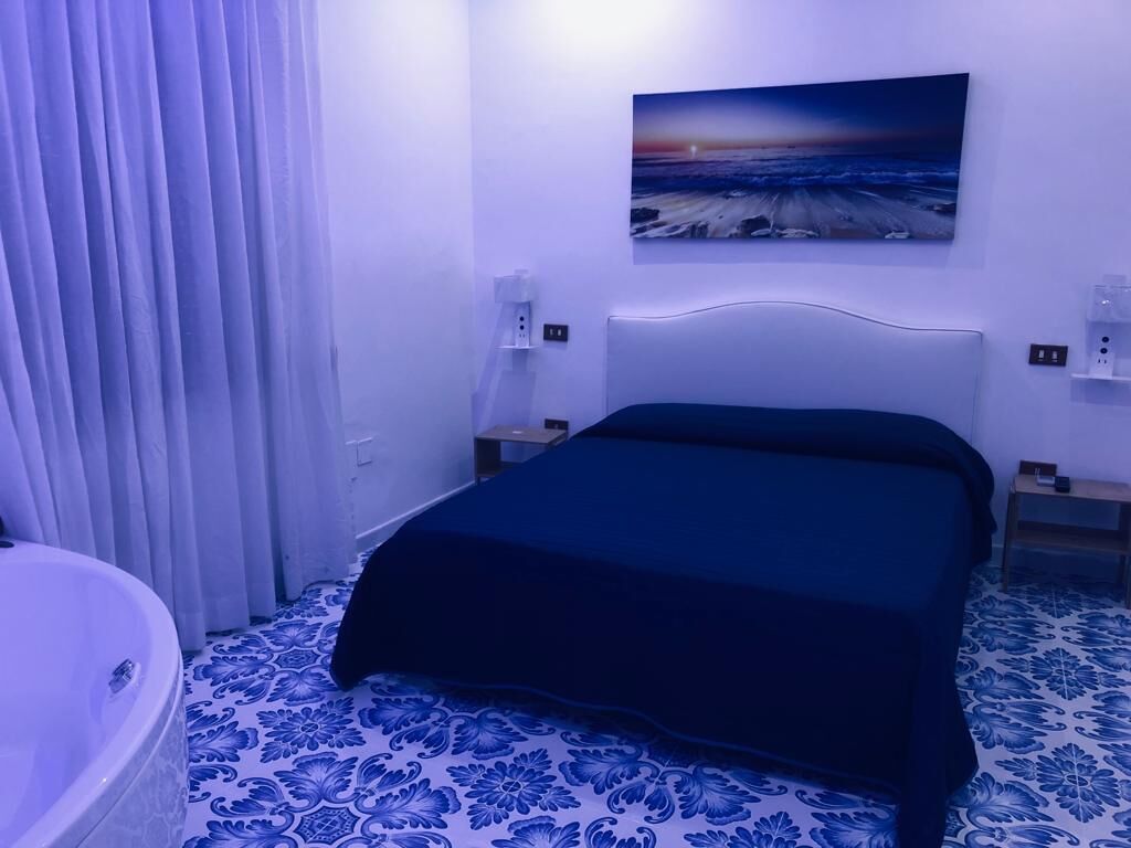 Un dormitorio con cama, un cuadro en la pared y un baño con bañera.