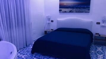 Un dormitorio con cama, un cuadro en la pared y un baño con bañera.