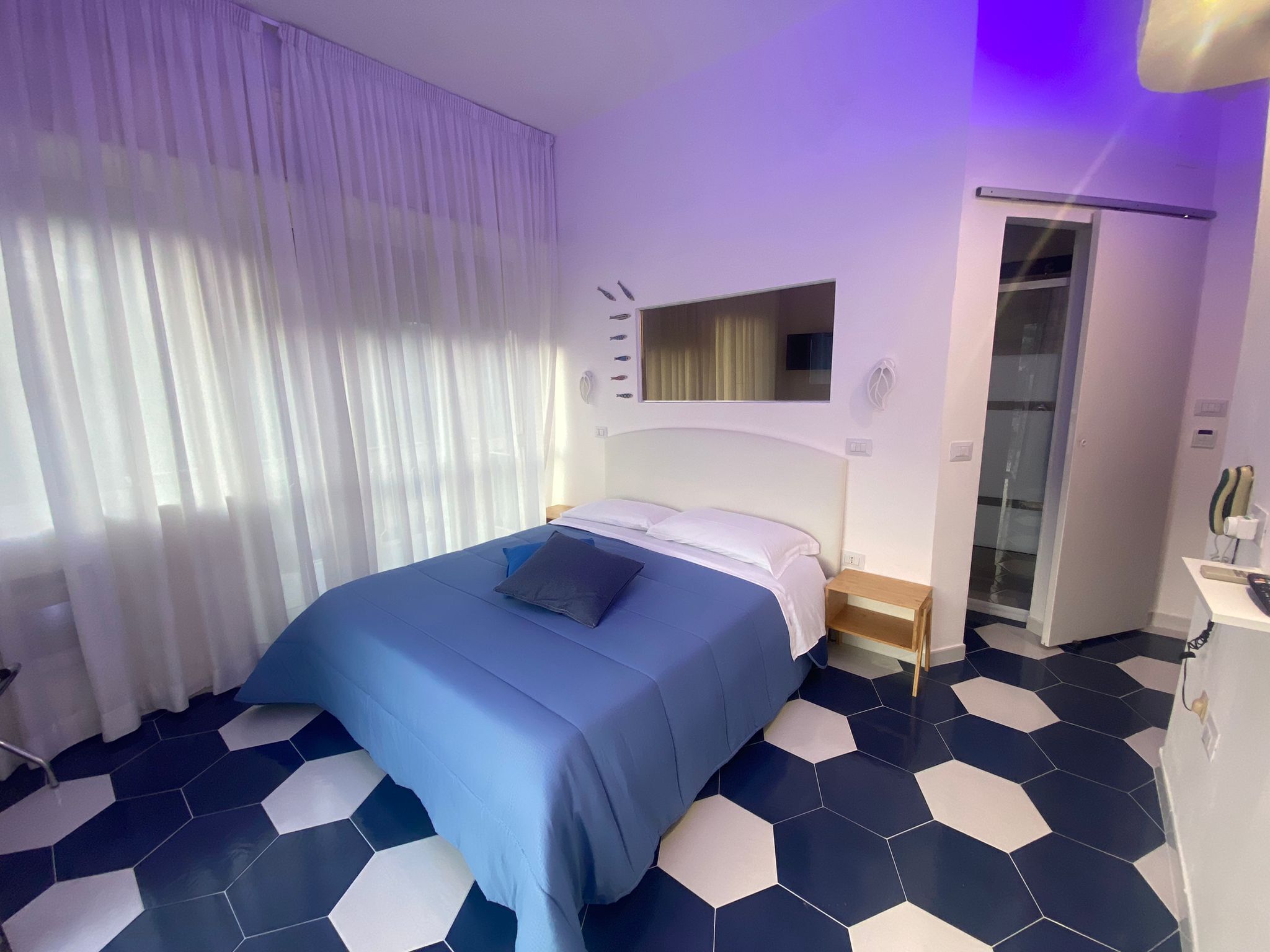 Una habitación de hotel con cama, armario y baño.