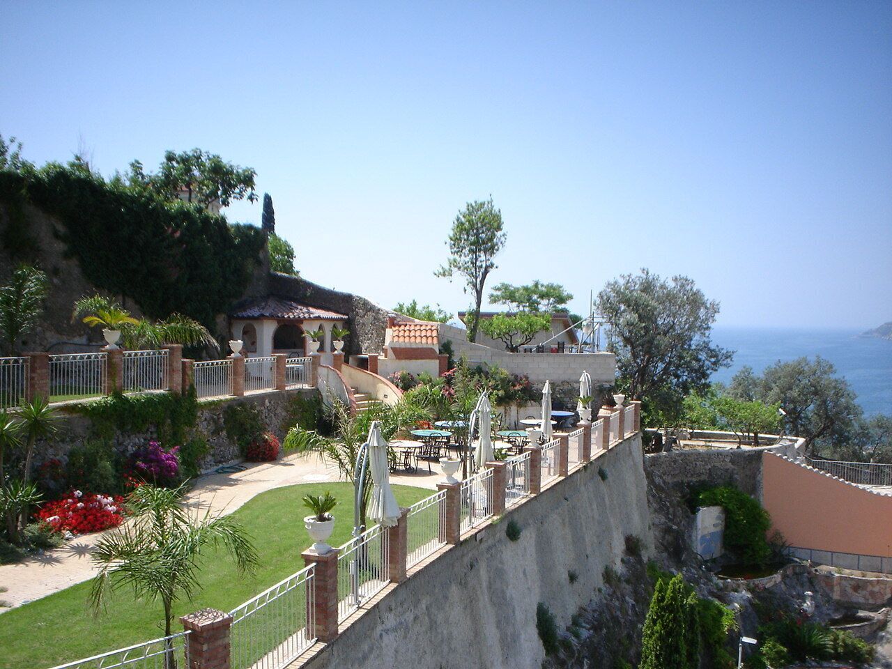 Une villa située sur la côte, dotée d’un patio, d’un espace salon extérieur et offrant une vue sur la mer.