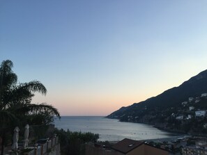 A coastal view with a clear sky, calm sea, and buildings on a hillside. - Hotel Vietri Coast (Vietri sul Mare)