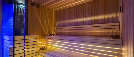 A modern sauna with wooden slats and warm lighting.