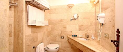 A bathroom with a sink, bidet, and towel rack.