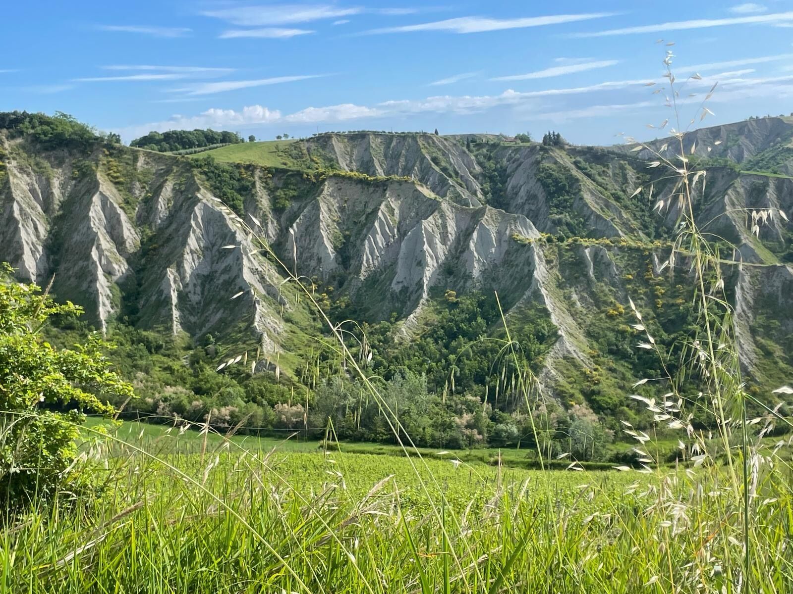 Un paisaje montañoso con campos verdes y acantilados.