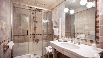 Une salle de bain moderne avec une douche à parois de verre, un meuble-lavabo à deux vasques et un grand miroir.