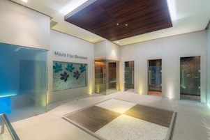 Um lobby moderno com parede de vidro, teto de madeira e chão de azulejos com padrão floral.