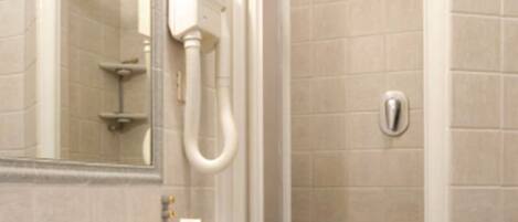 A bathroom with a white sink, a mirror, and a glass-enclosed shower.