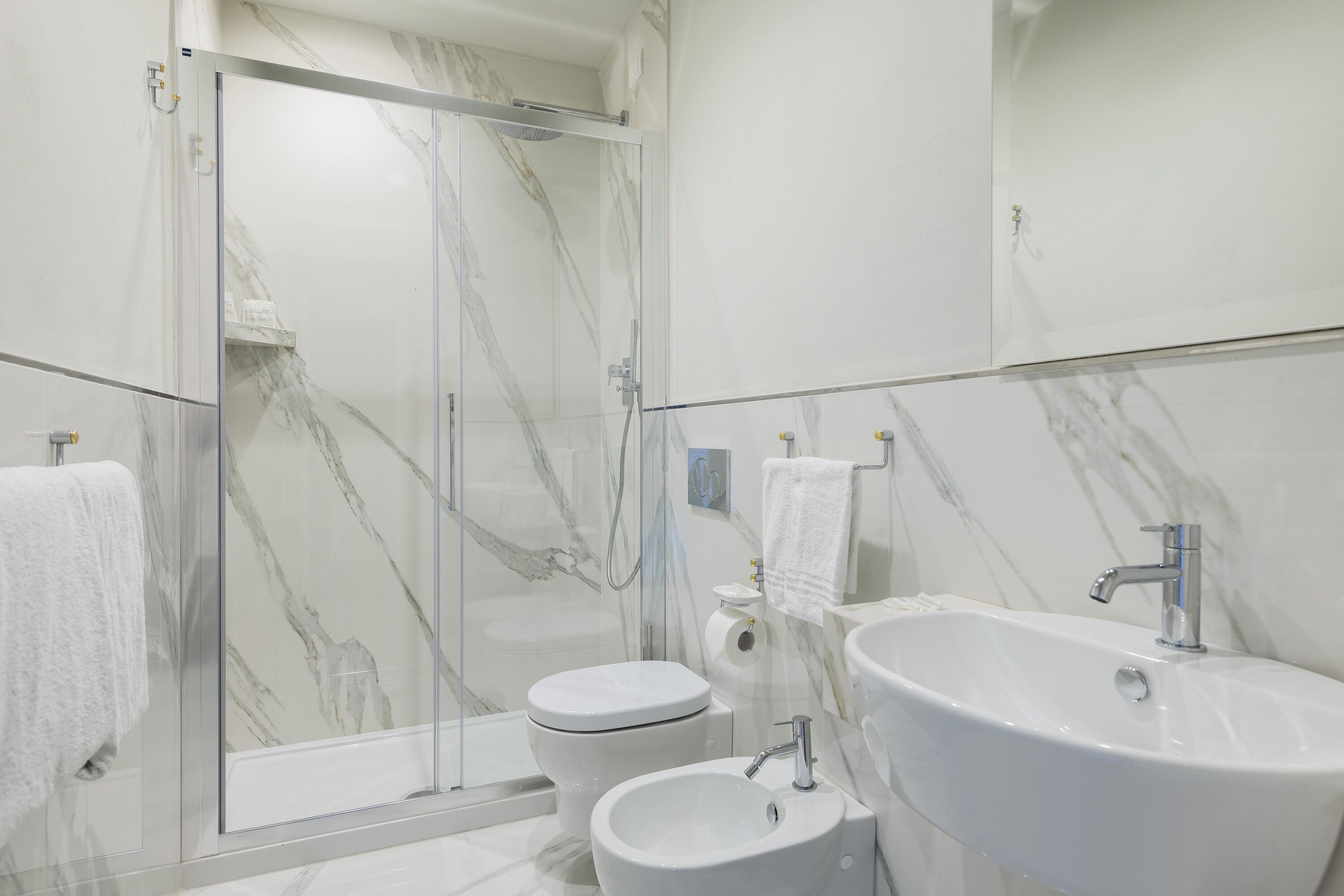 Un baño moderno con cabina de ducha de vidrio, inodoro y lavabo.