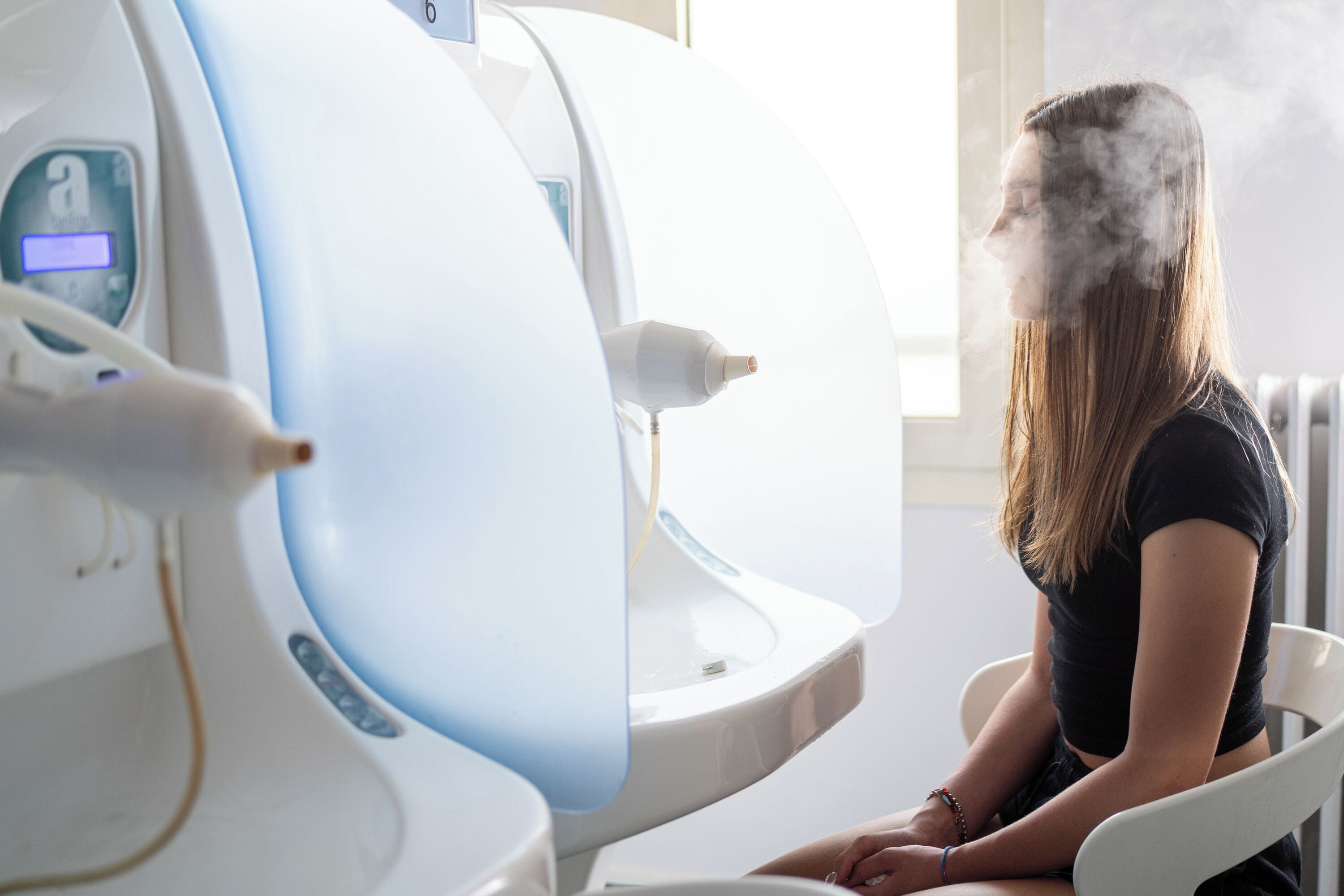 Una persona seduta su una sedia accanto a un macchinario per immagini mediche.