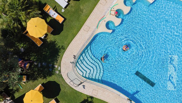 An aerial view of a swimming pool with multiple lanes, surrounded by lounge chairs and umbrellas. - Hotel Terme Helvetia (Abano Terme)