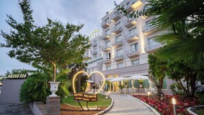 A hotel entrance with a sign reading 'Hotel Helvetia Abano Terme Italy,' surrounded by greenery and a cobblestone path. - Hotel Terme Helvetia (Abano Terme)