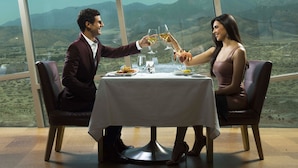 A dining table with a white tablecloth, two chairs, and a view of mountains through large windows. - Morongo Casino Resort Spa (Cabazon)